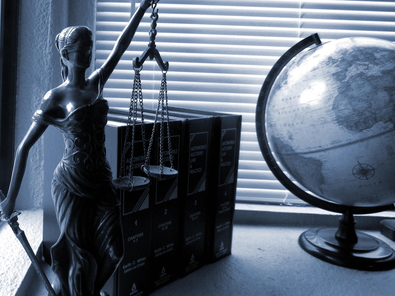 Scales of justice resting on legal volumes